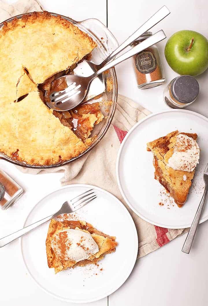 Two slices of apple pie on white plates