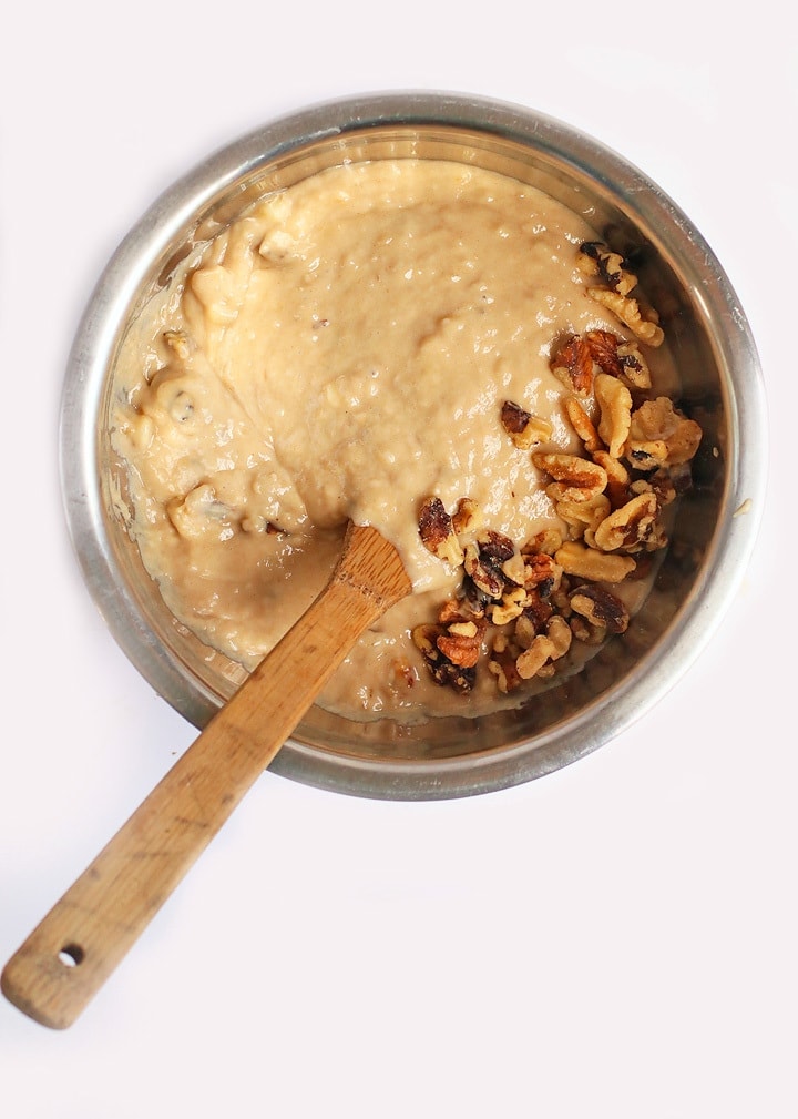 Muffin batter in a metal bowl with a wooden spoon