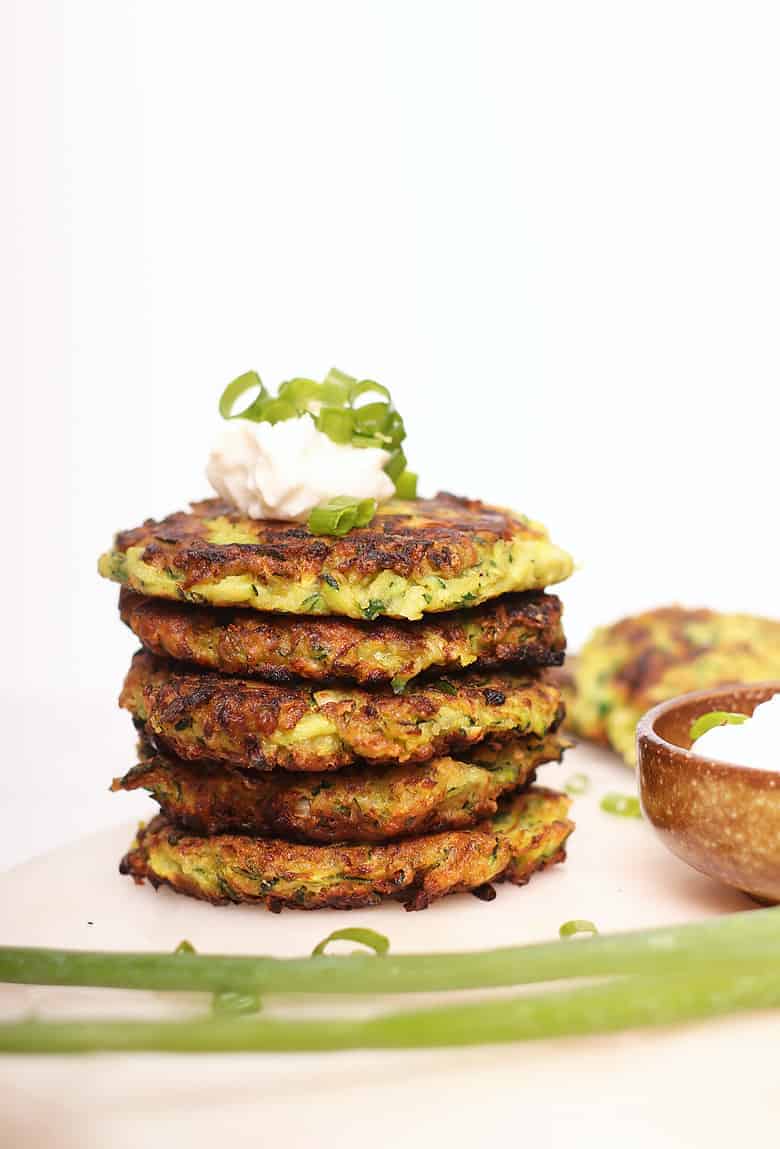 Stack of vegan zucchini fritters with sour cream