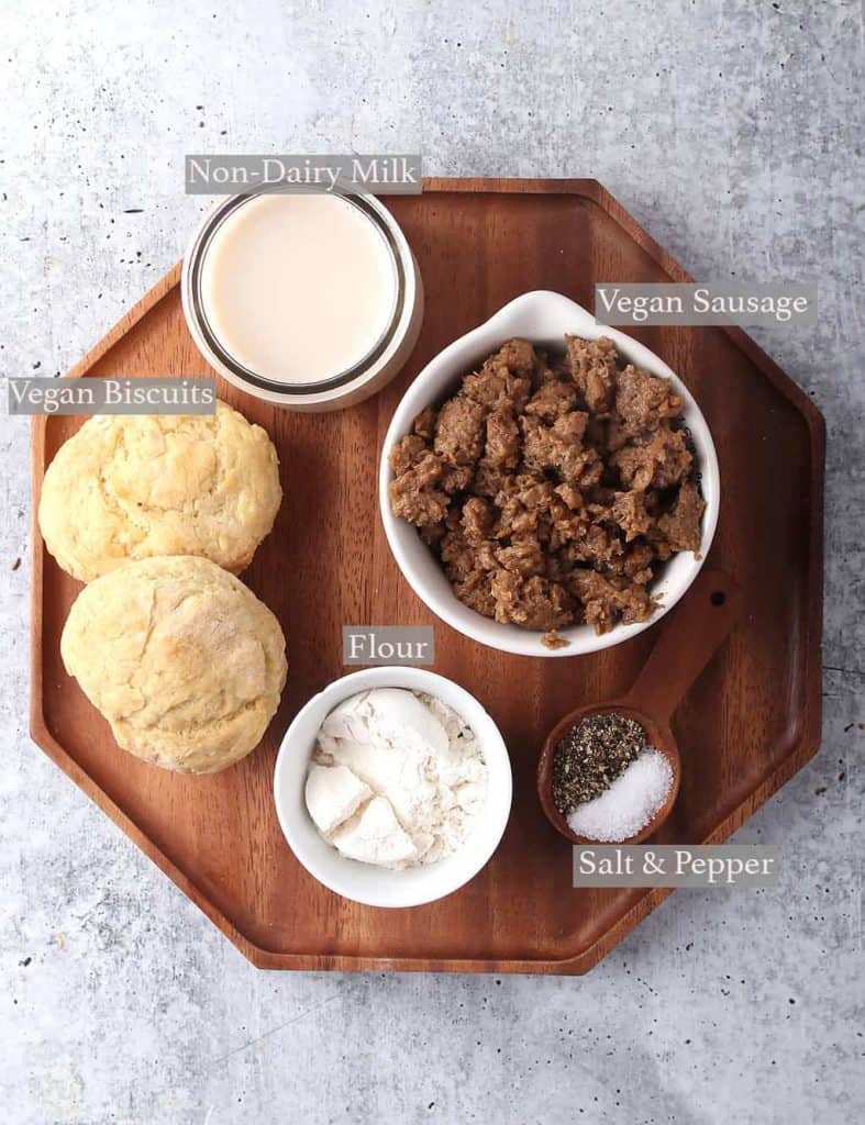 Ingredients for biscuits and gravy on a wooden platter