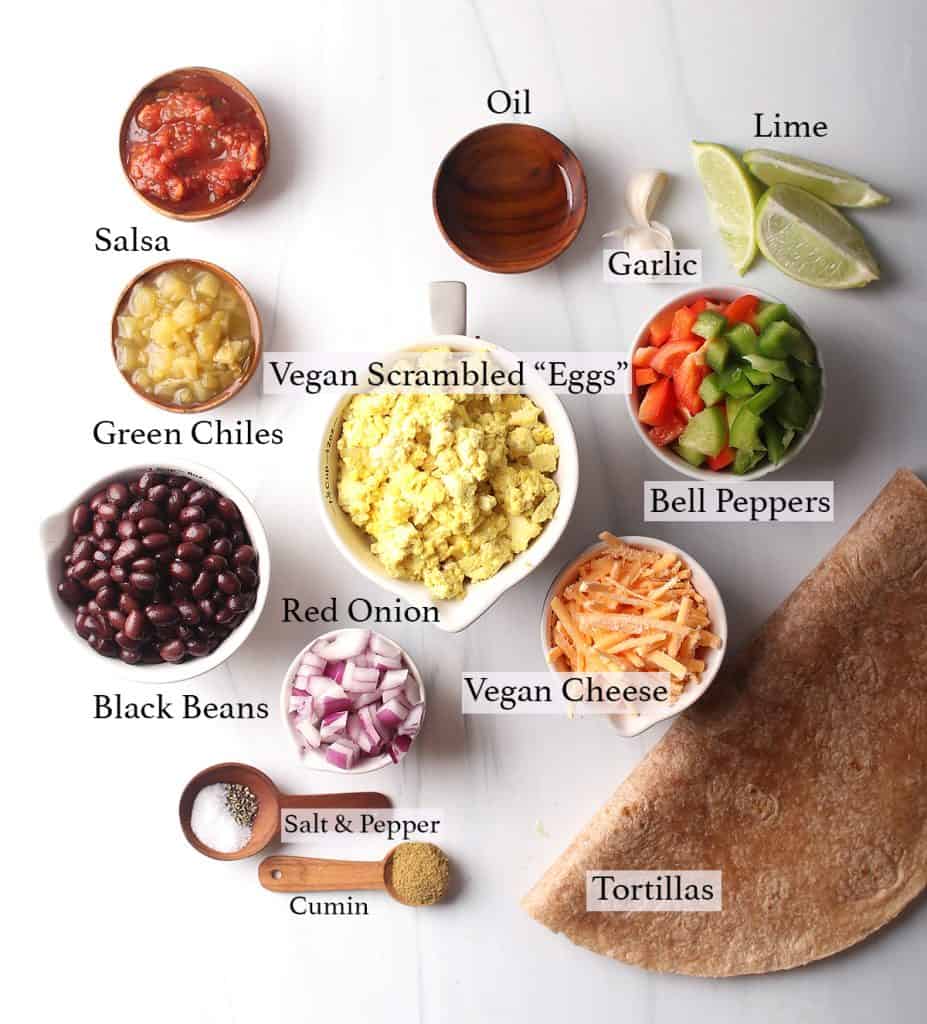 Ingredients for vegan breakfast burrito measured out on a marble countertop