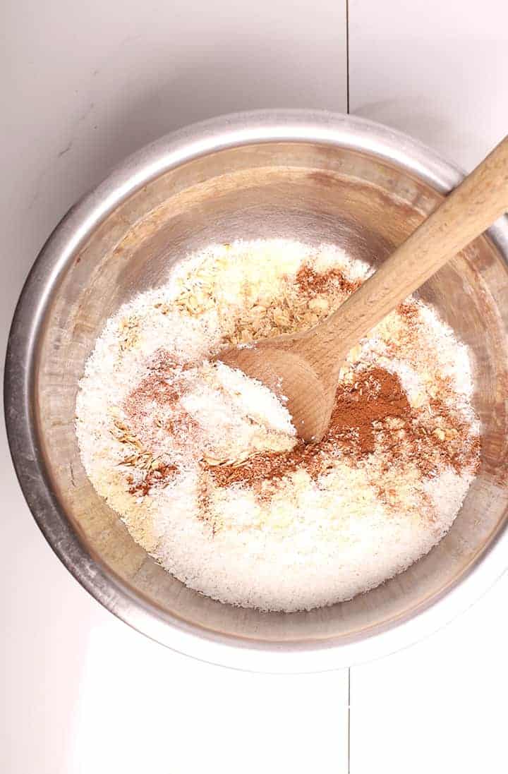 Oats, coconut, and spices in a mixing bowl
