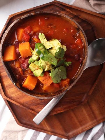 Bowl of finished chili with cilantro and avocado