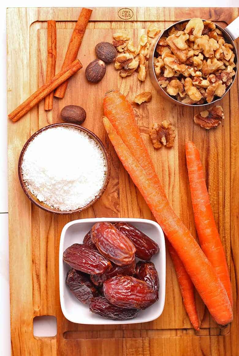 Dates, carrots, walnuts, and shredded coconut on a cutting board