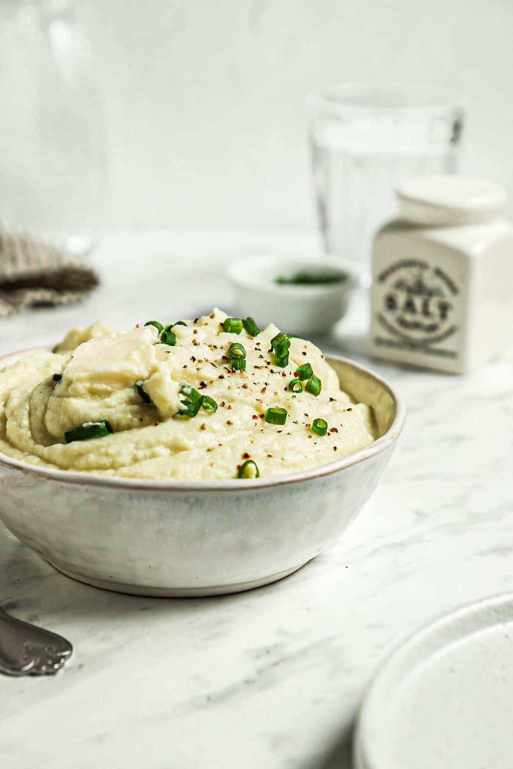 Bowl of mashed cauliflower with fresh chives and vegan butter