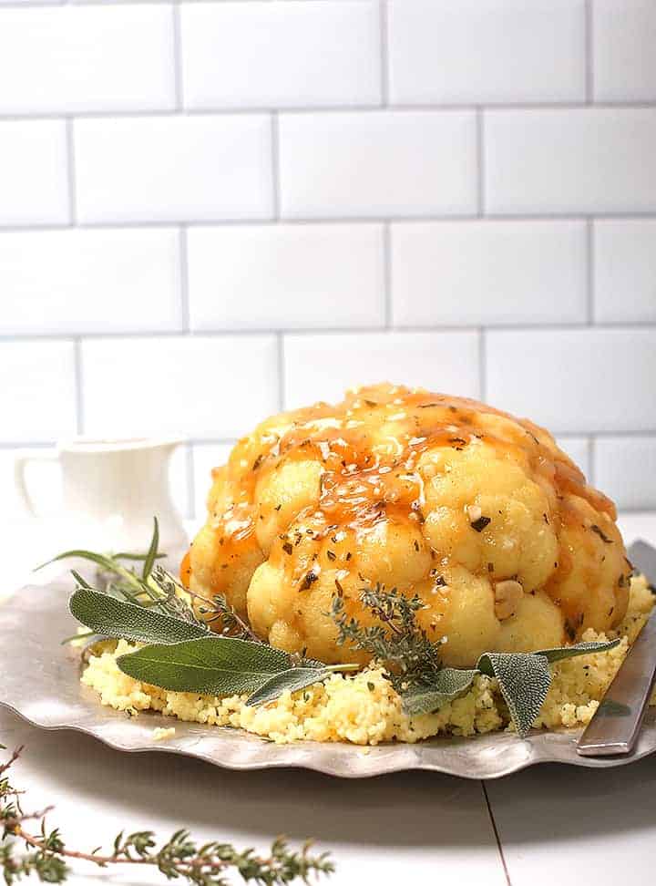 Whole Roasted Cauliflower with gravy on silver platter