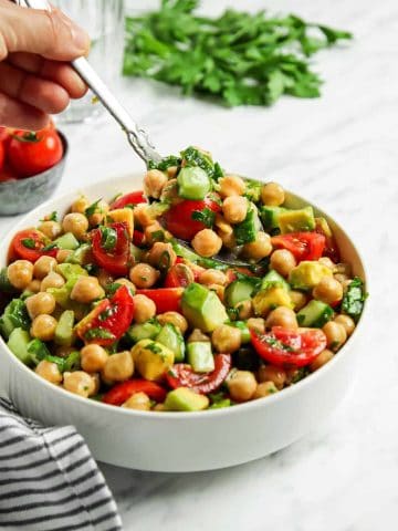 Spoonful of chickpea salad over white bowl