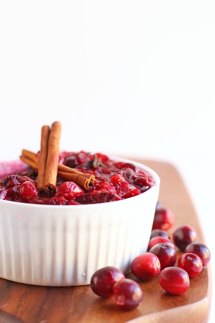 Homemade Cranberry Sauce in a small white bowl with cinnamon sticks