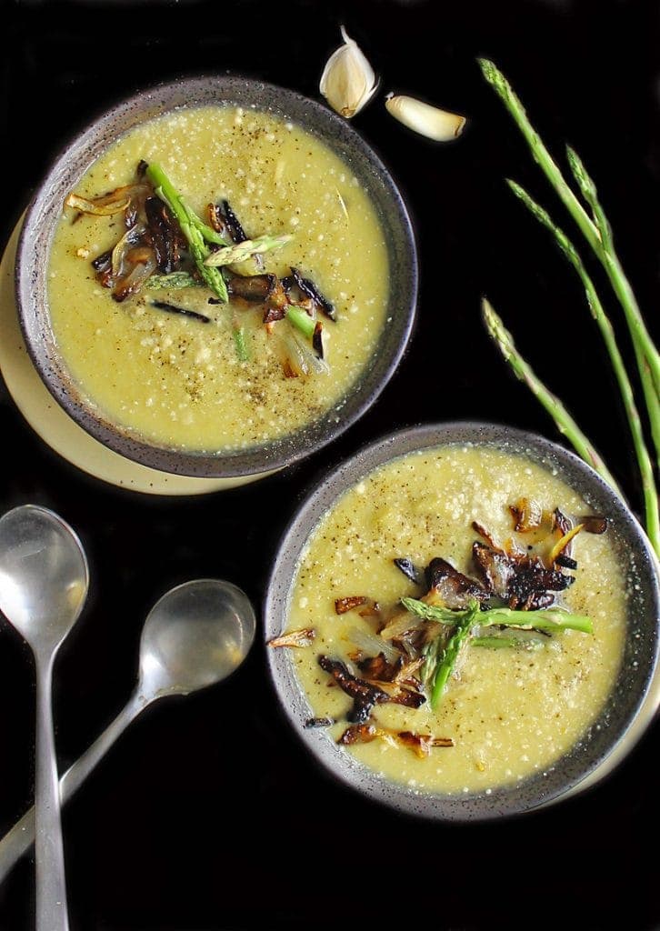 Two bowls of cream of asparagus soup with caramelized onions. 