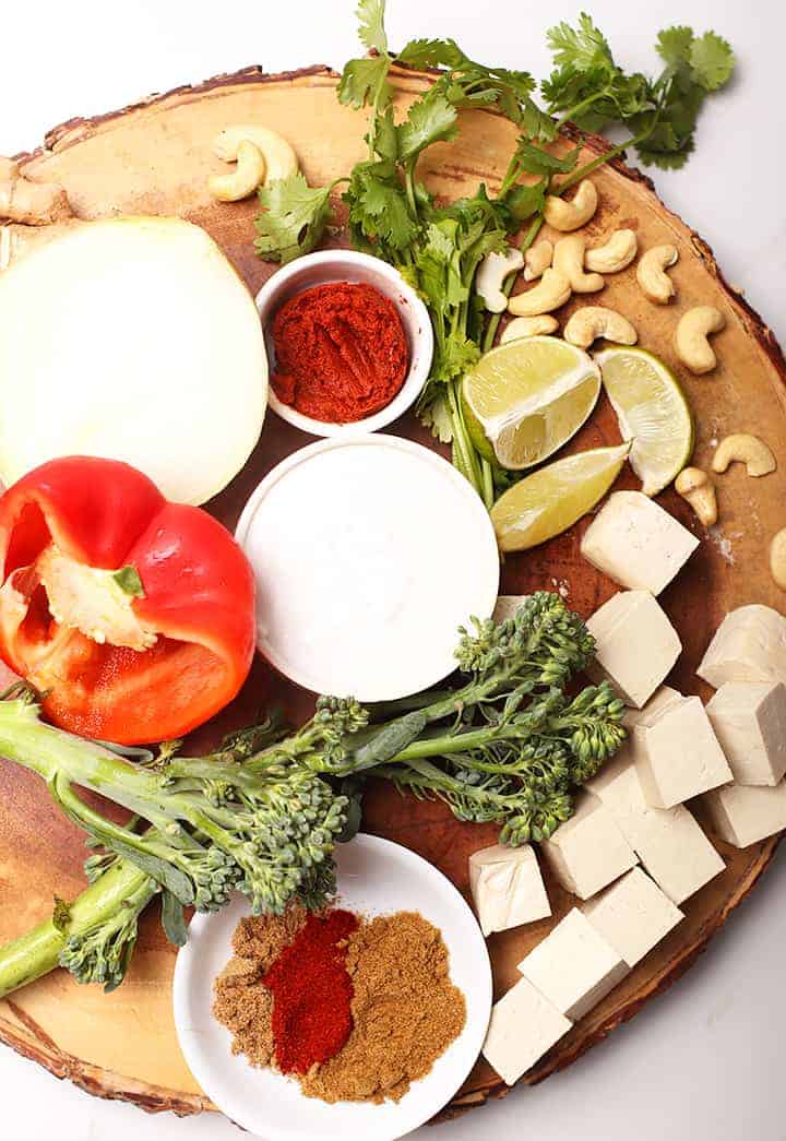 Spices, vegetables, and tofu on wooden platter