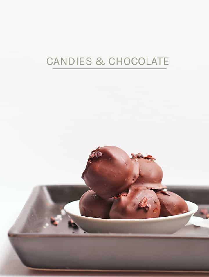 Chocolate Truffles in a small white bowl on a black board. 