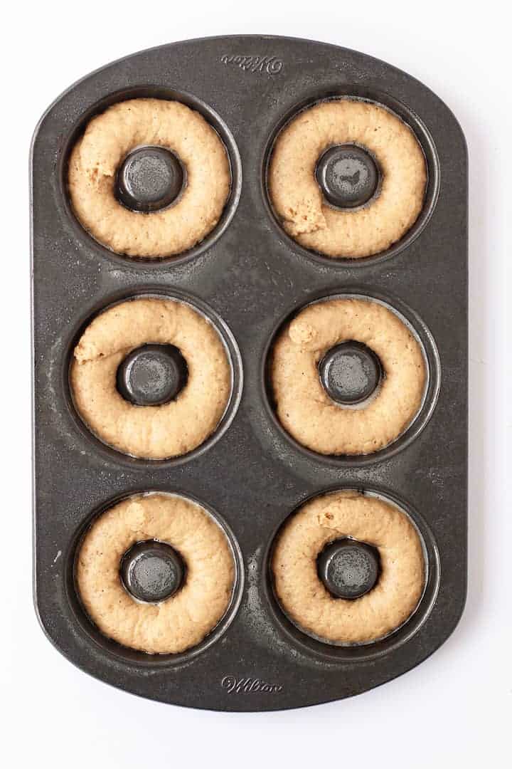 Donut batter piped into a donut pan