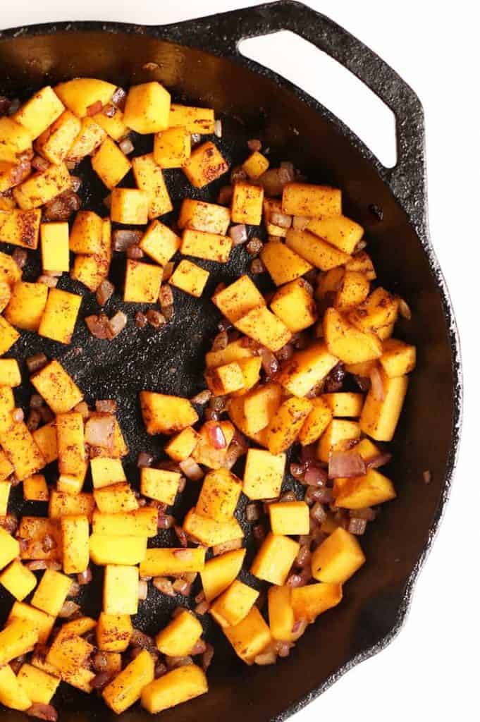 Sautéed onions and squash in a cast iron skillet