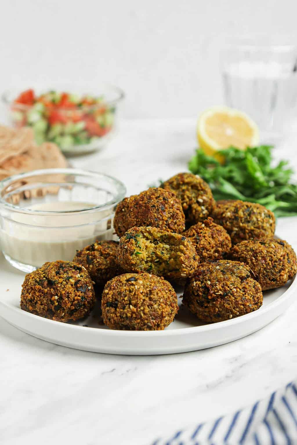front view of authentic falafel on white plate with sauce