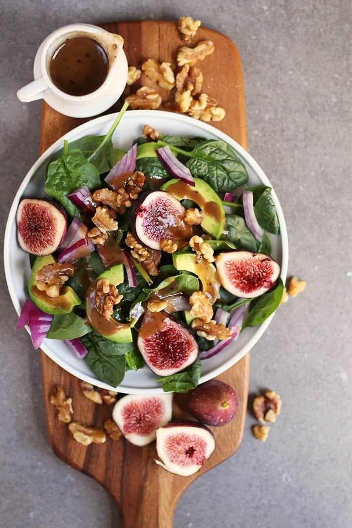 Fig Spinach Salad with balsamic vinaigrette on a wooden board. 