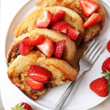 Classic Vegan French Toast with sliced strawberries and maple syrup.