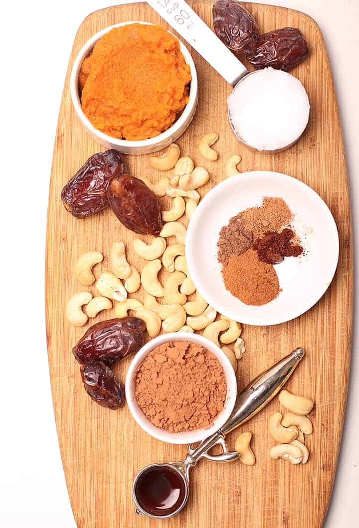 spices, cashews, dates, and pumpkin puree on a wooden platter