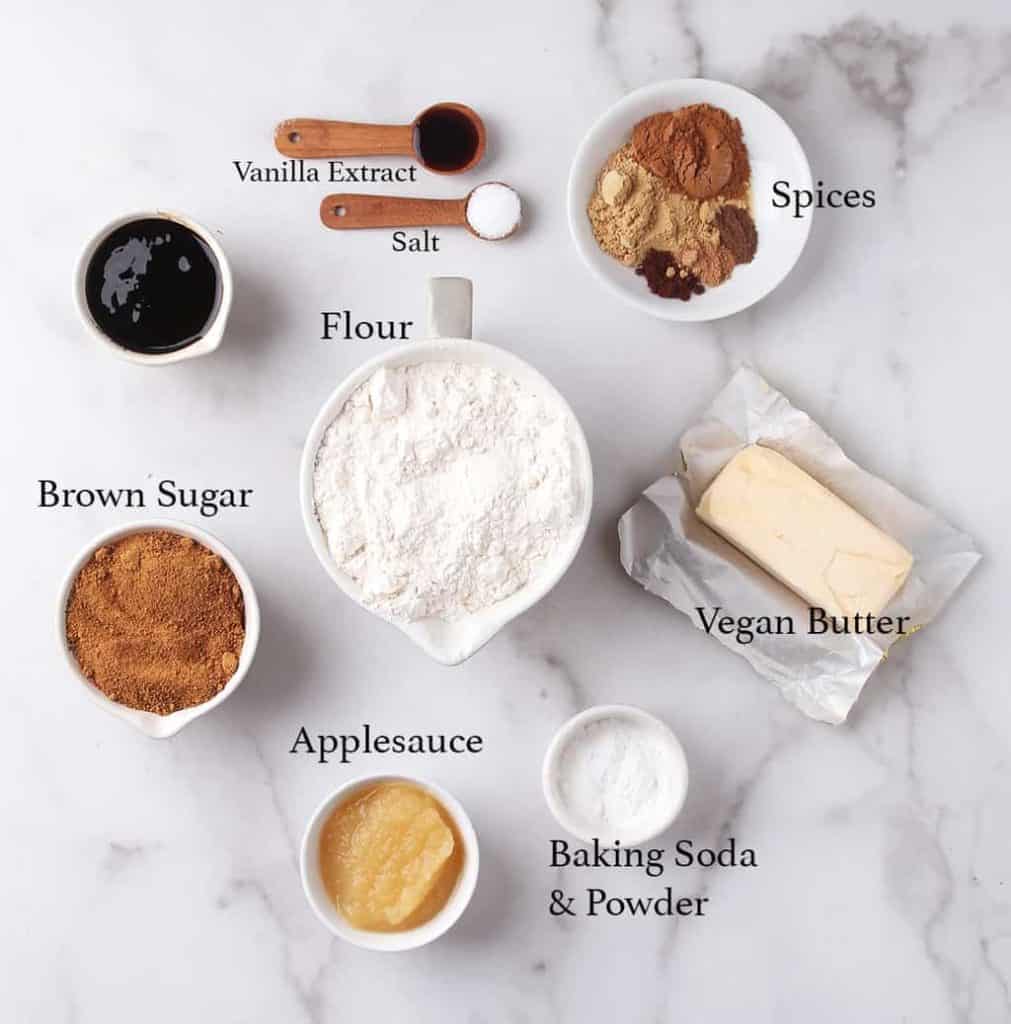 Ingredients for gingerbread cookies measured out and placed on a marble countertop