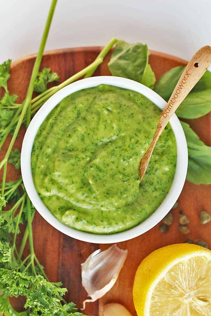 Green Goddess Dressing in a small white bowl with fresh herbs