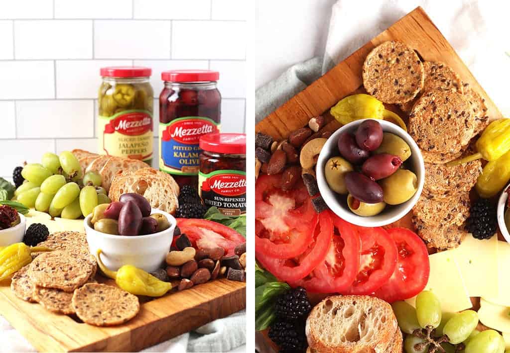 Pickles, tomatoes, bread, and olives on wooden platter
