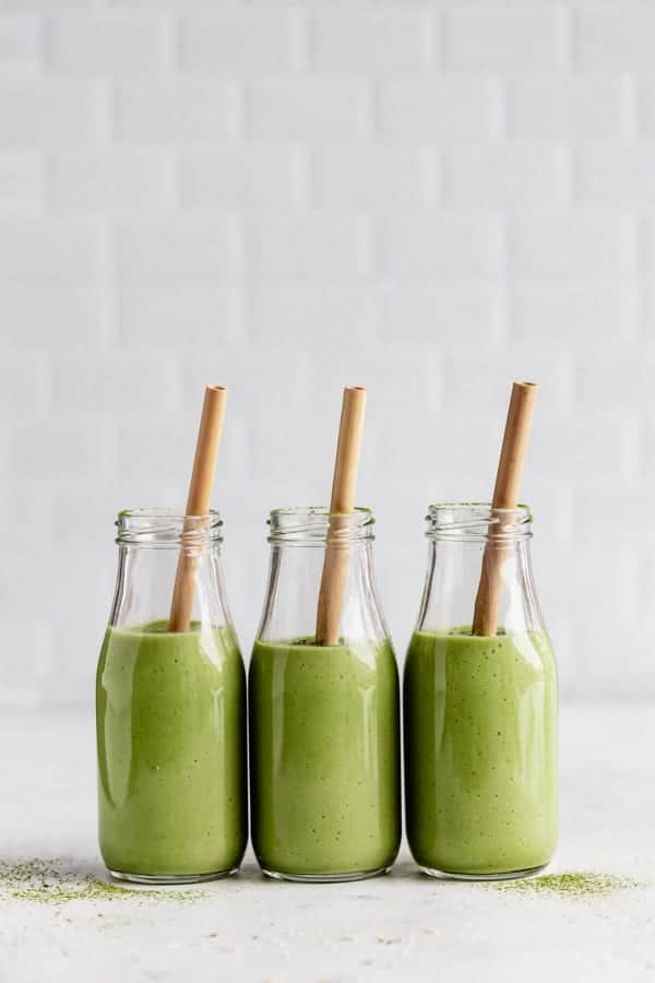 3 glasses of green smoothies with straws