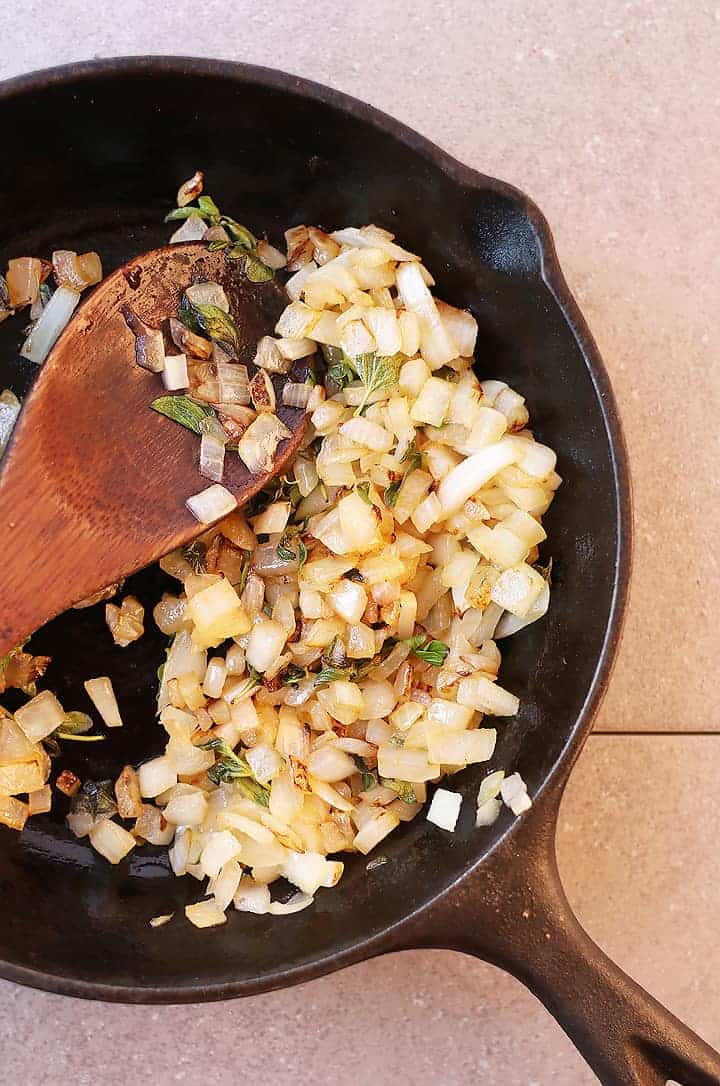 Sautéed onions and herbs in a skillet