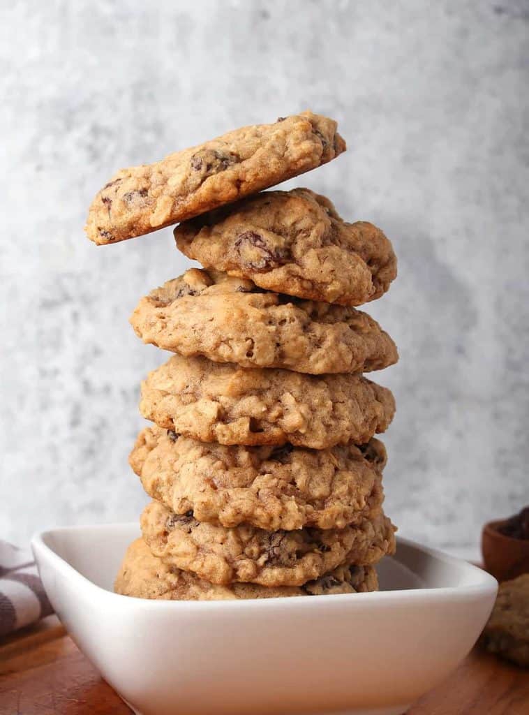Stack of vegan oatmeal raisin cookies in a small white bowl 