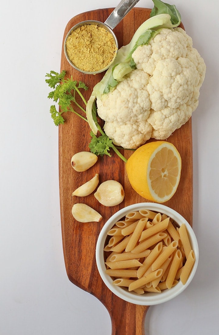 Penne Pasta, cauliflower, and garlic on a cutting board