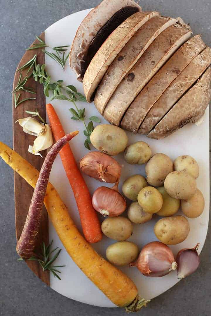 Mushrooms, potatoes, carrots, and garlic on cutting board