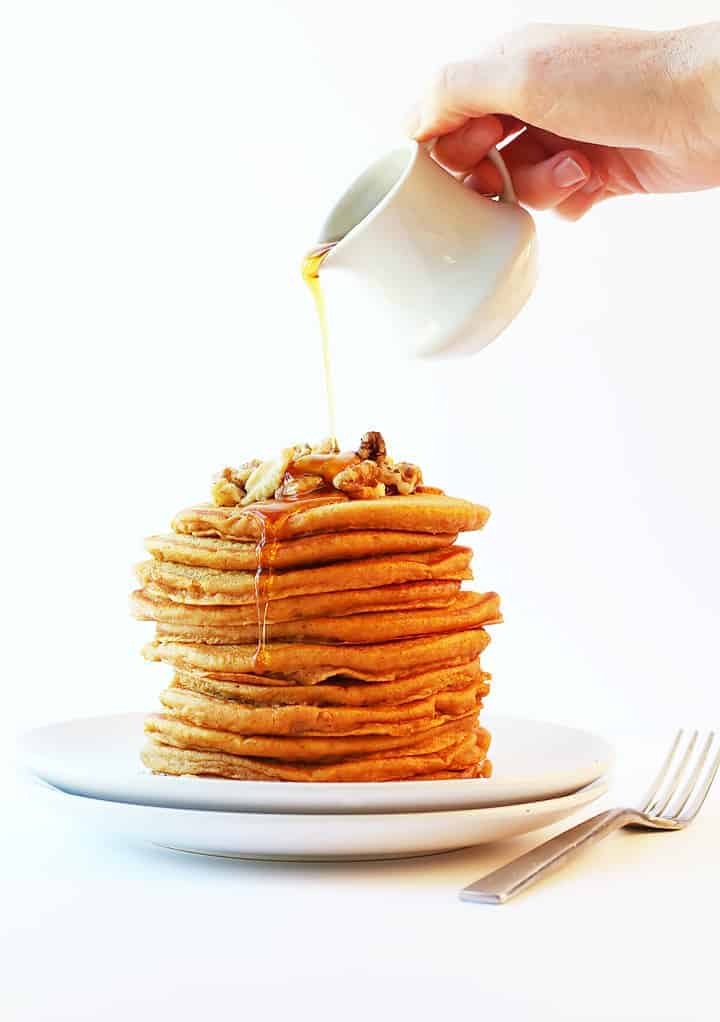 Stack of vegan pumpkin pancakes with maple syrup