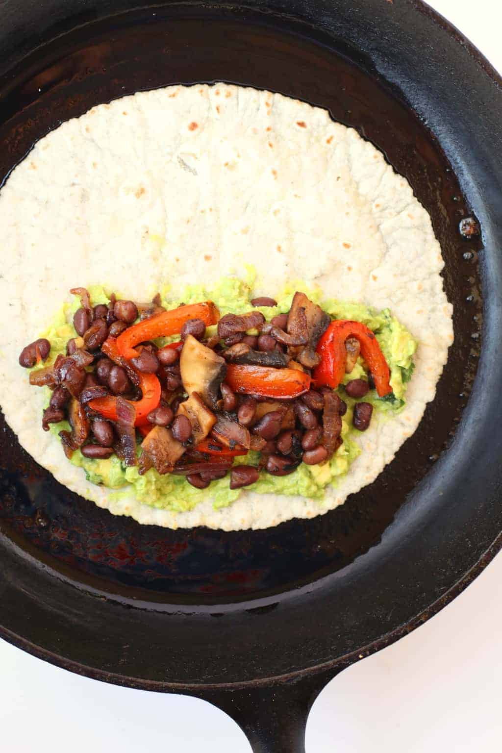 Tortilla with beans and veggies in a cast iron skillet