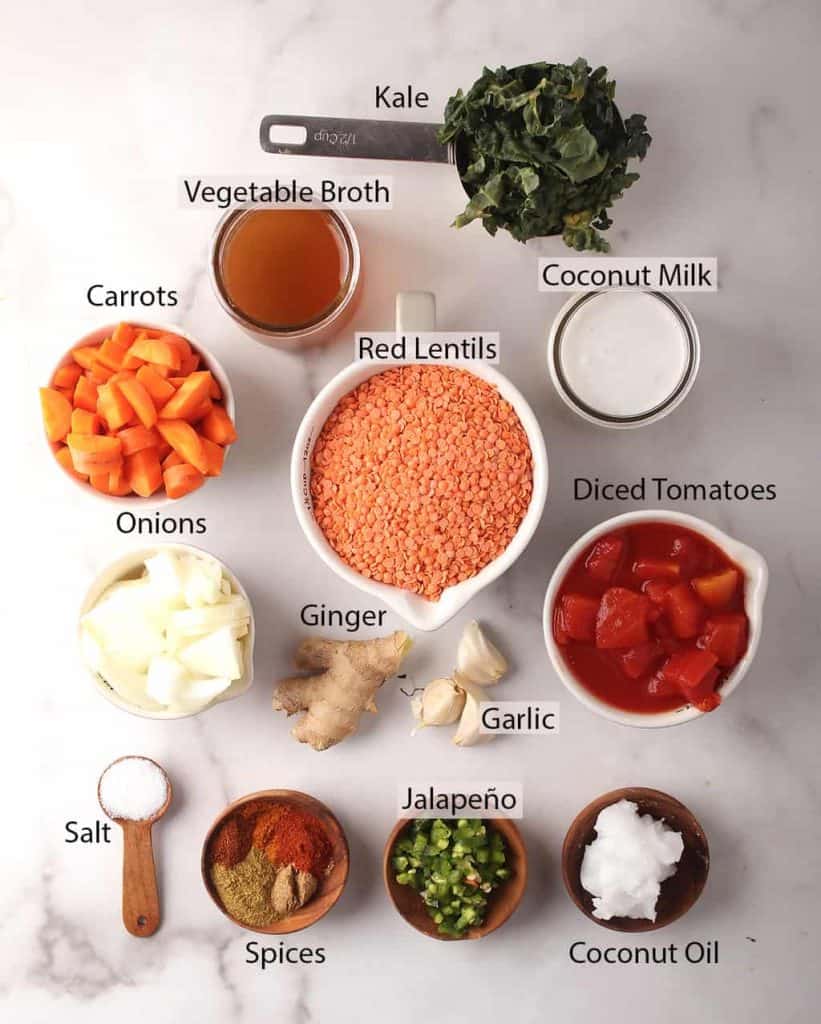 ingredients for simple red lentil dahl recipe laid out on a white marble tabletop