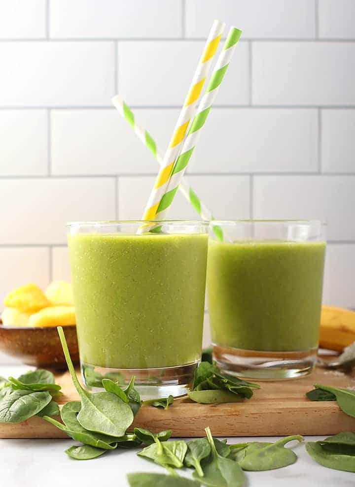 Two vegan green smoothie with striped straws