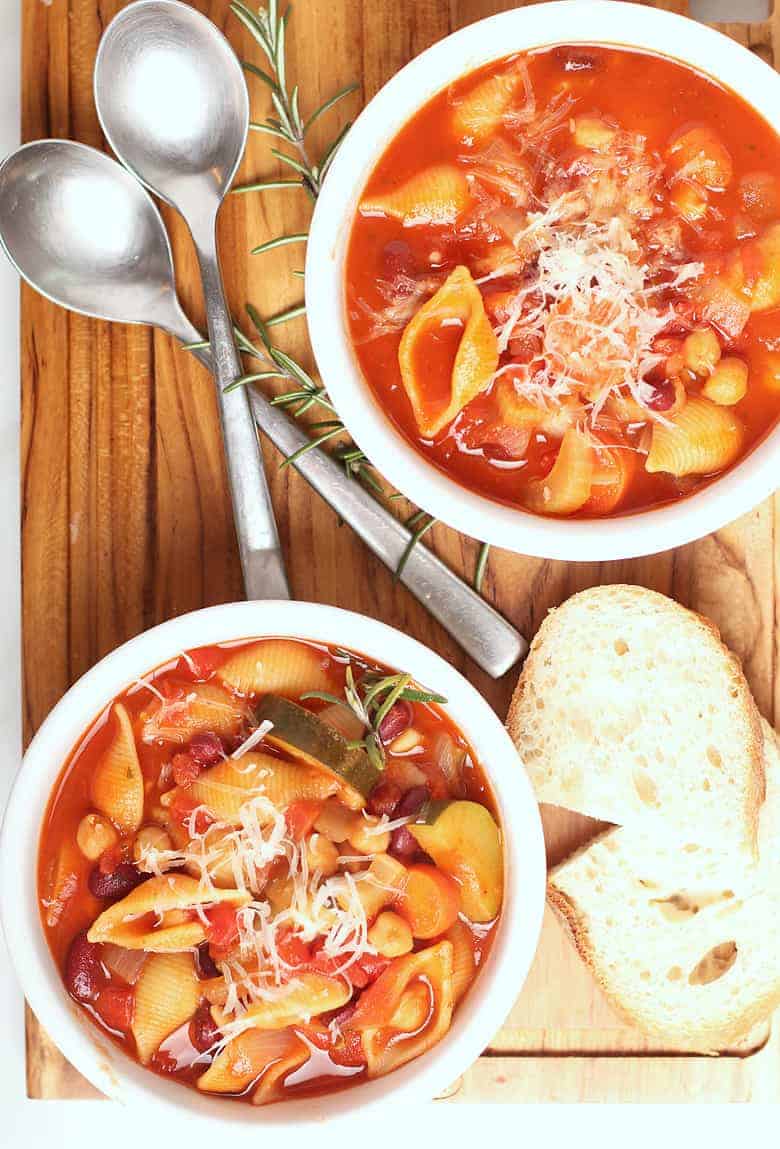 Minestrone soup in a white bowl with spoons