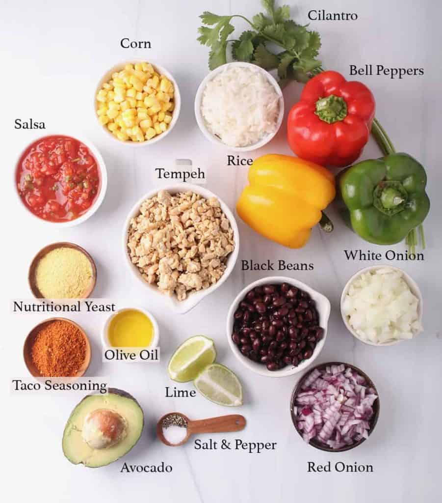 Ingredients for stuffed bell peppers, measured out in small white bowls.