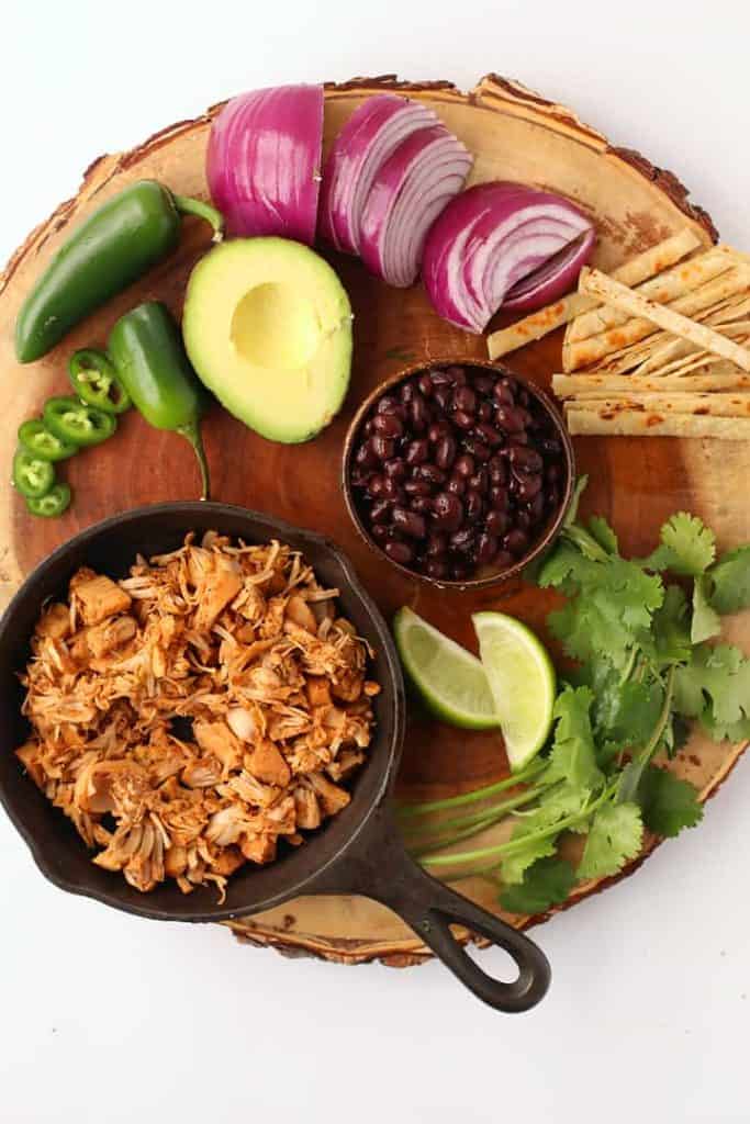 Jackfruit, black beans, avocado, and onions on a wooden platter