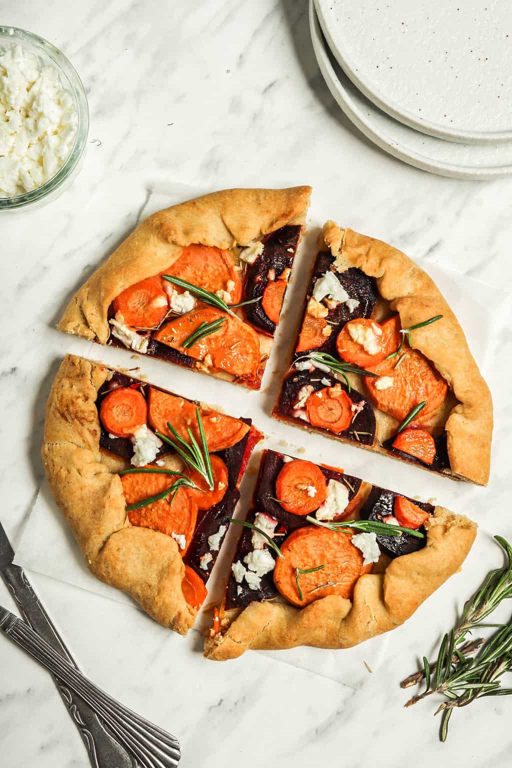 Finished vegan galette cut into four pieces and placed on a white parchment paper. 