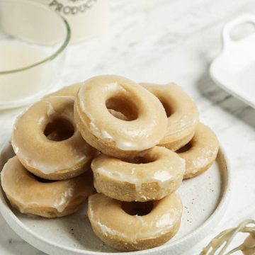 plate of vegan donuts with vanilla glaze and coffee container in background