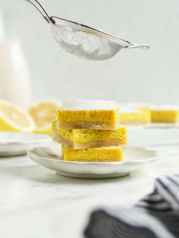 three lemon bars on top of each other with powdered sugar