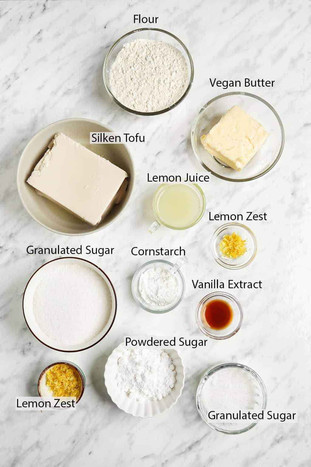 sugar, lemon juice and zest, vanilla, flour, cornstarch, tofu, vegan butter on white surface