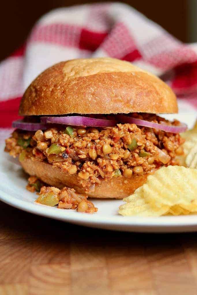 Vegan sloppy joes in a bun with chips on the side 