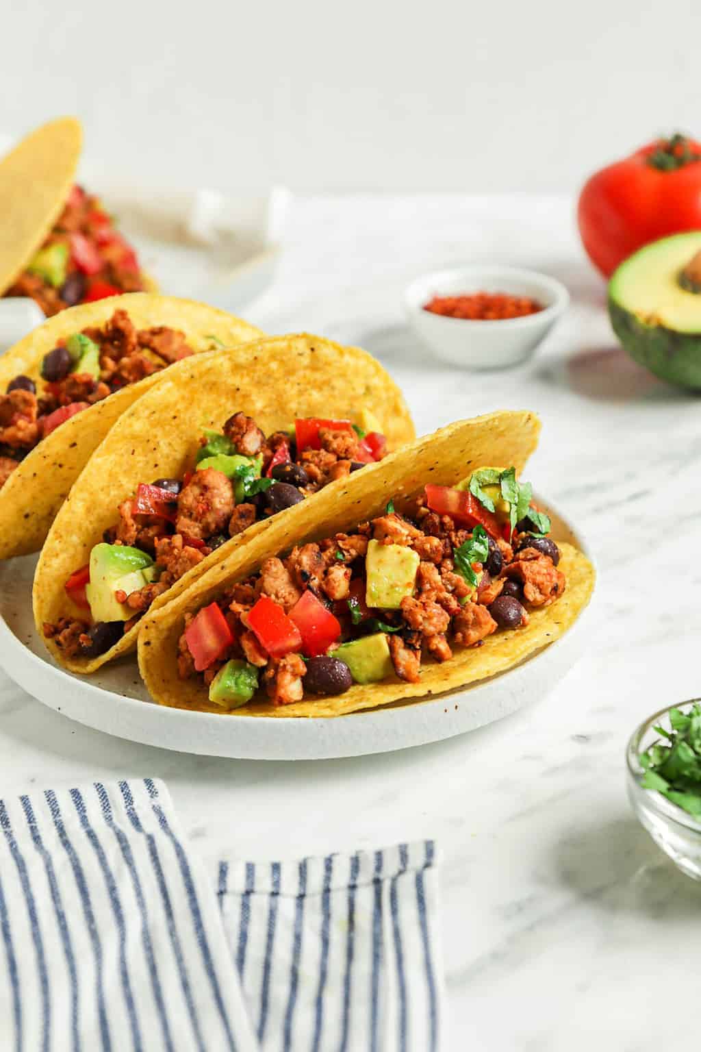 close up of three classic vegan tacos on white plate 