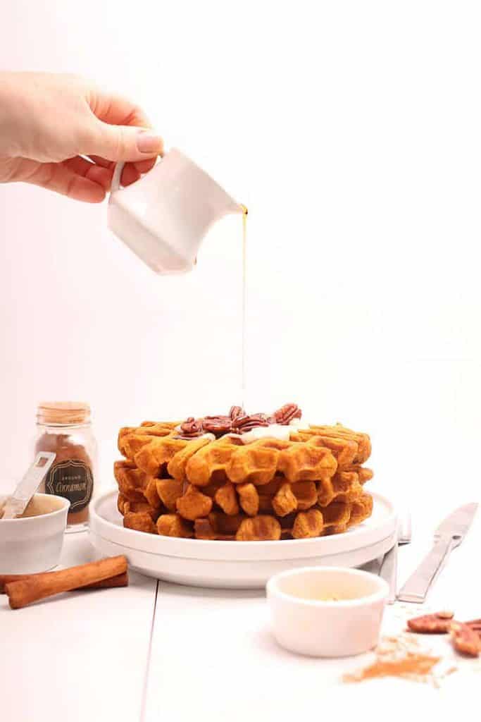 Stack of pumpkin waffles with maple syrup