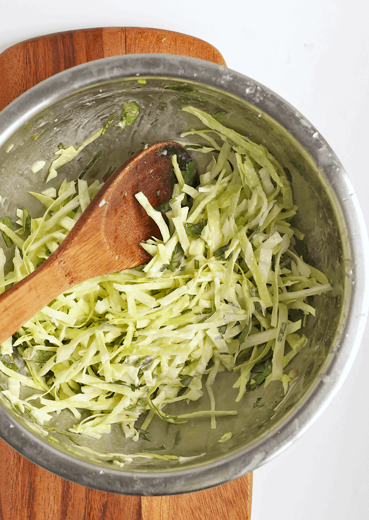 Shredded cabbage and cilantro in a metal bowl